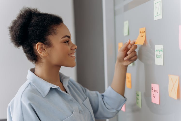 Side View Of Woman Holding Orange Sticky Notes 