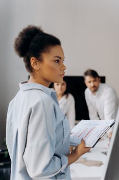 Focused African American woman presenting during office meeting, showcasing leadership.