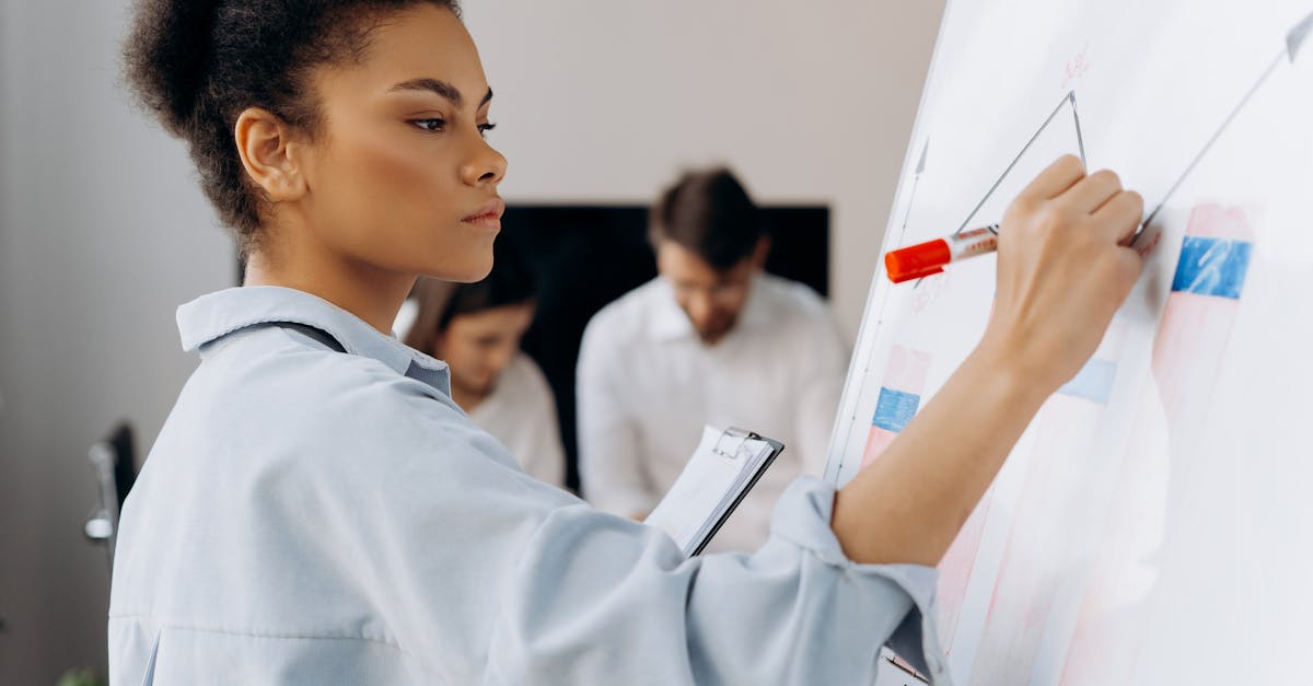 Confident businesswoman illustrates data on whiteboard during a team meeting, showcasing collaborative analysis.