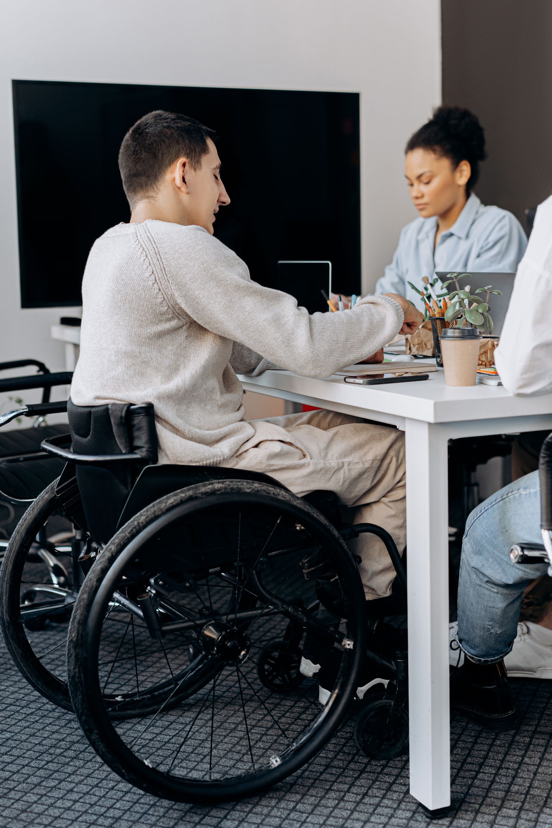 Colleagues collaborating in an inclusive workplace, including a professional who uses a wheelchair