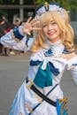 A Cute Cosplayer in White Costume Posing Beautifully at the Camera
