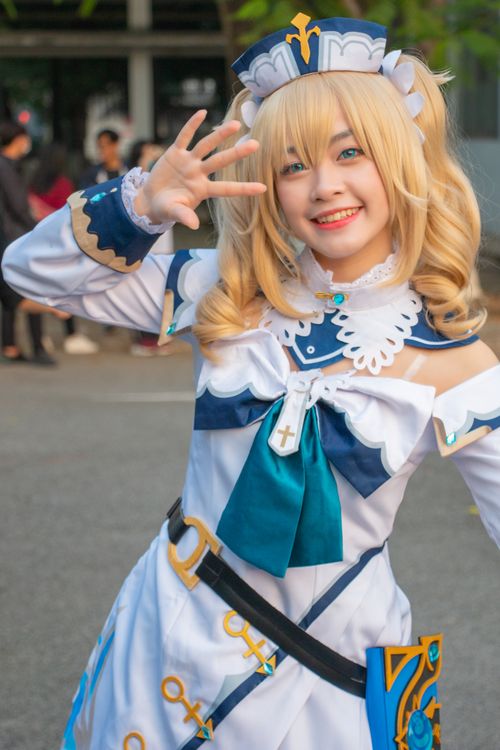 Free Cheerful cosplayer in detailed anime costume smiling and posing outdoors with vibrant energy. Stock Photo
