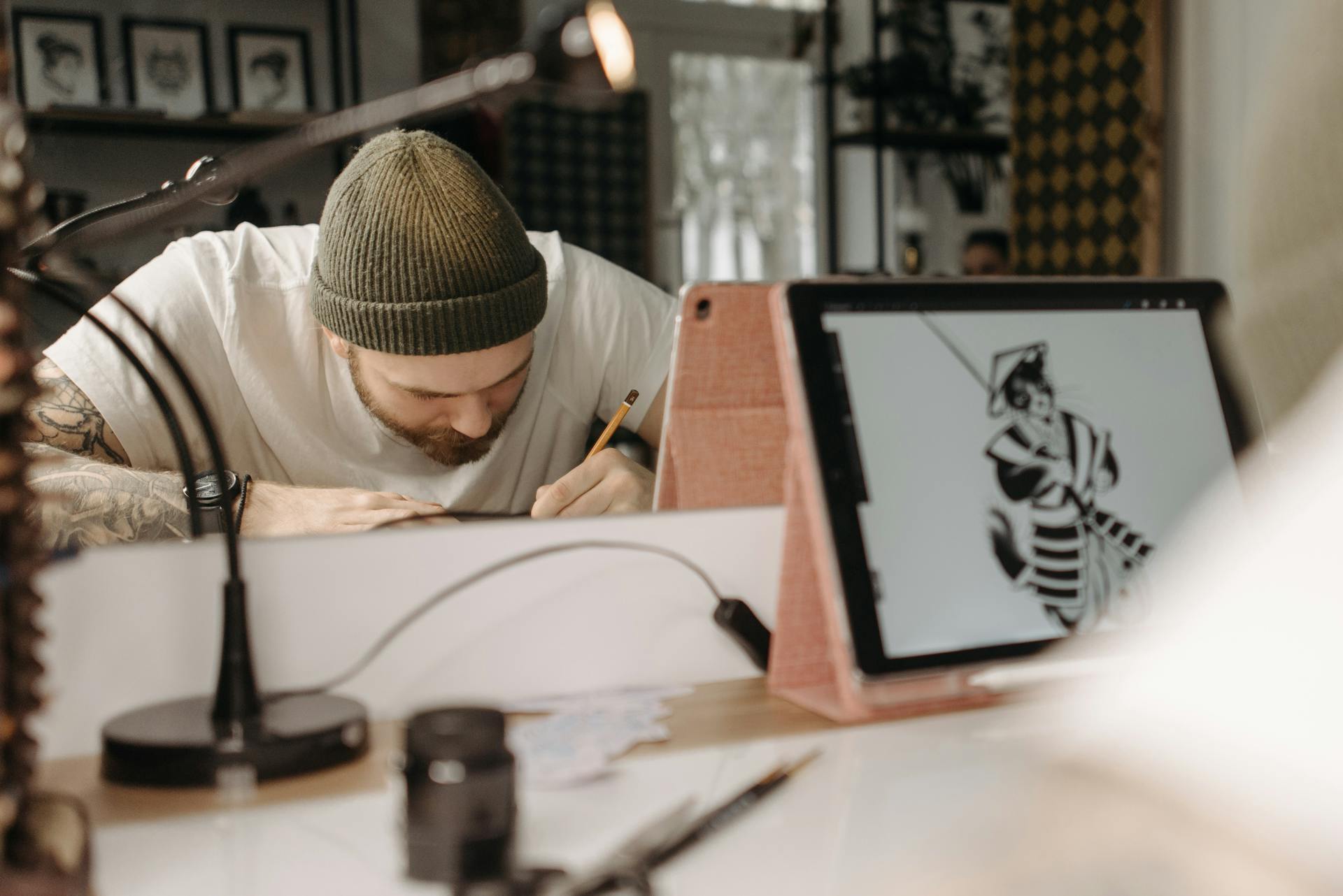 Artist deeply engaged in sketching with an iPad in a contemporary studio environment.