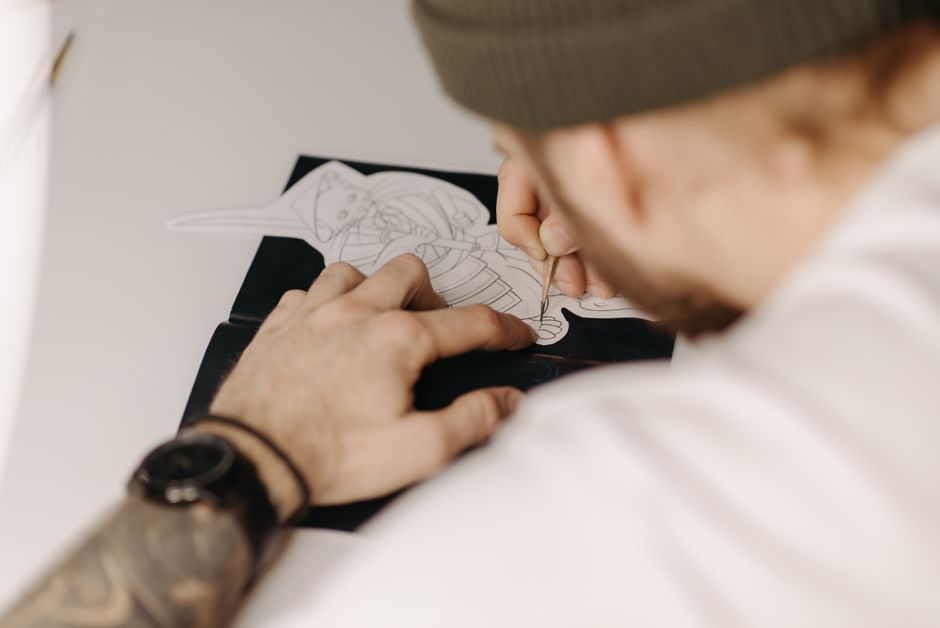 Aspiring tattoo apprentice practicing illustrative linework on synthetic skin Aspiring tattoo apprentice practicing illustrative linework on synthetic skin