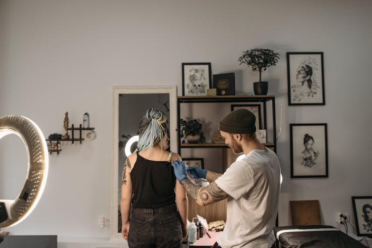 Man Making Tattoos On Woman Shoulder