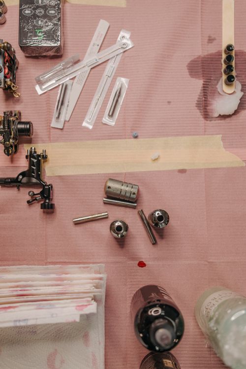 Free Flat lay of tattoo equipment arranged on a worktable for precise artistry. Stock Photo