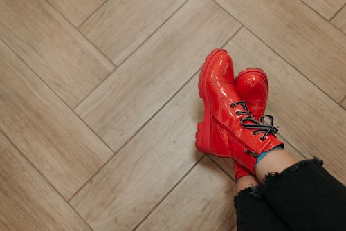 Free Stylish red boots on a wooden herringbone floor. Fashionable footwear concept. Stock Photo