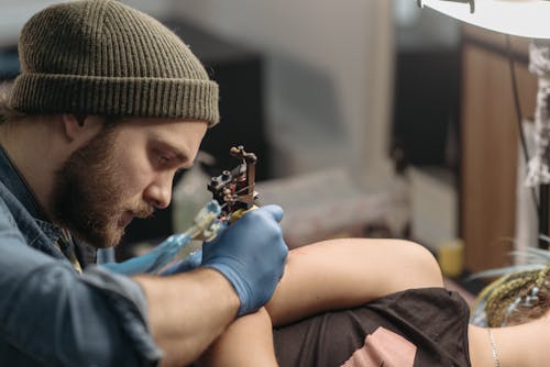Bearded Man Tattooing a Client
