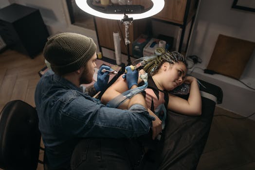 A tattoo artist skillfully working on a client's arm in a modern tattoo studio.