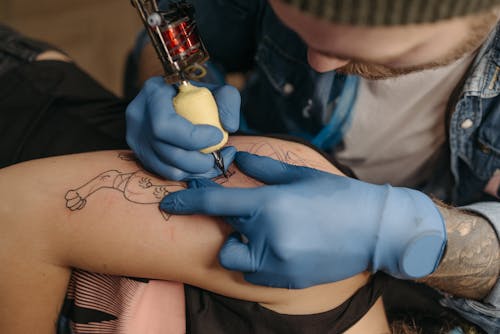 Tattoo Artist Working on a Client