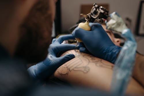 Tattoo Artist Tattooing a Client's Arm