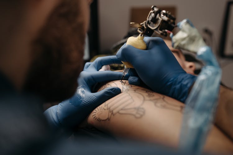 Tattoo Artist Tattooing A Client's Arm