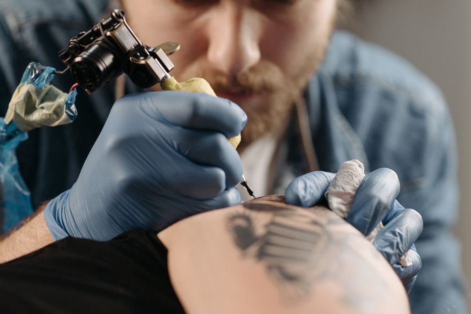 A professional tattoo artist sanitizing their workspace before a session.