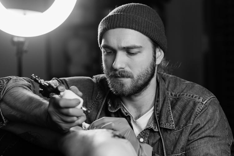 Black And White Photo Of A Tattoo Artist 