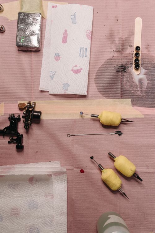 Free Flat lay of various tattoo equipment and tools arranged on a surface. Stock Photo