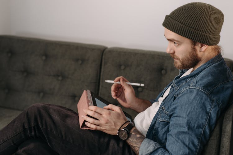 Side View Of A Man Working On His Tablet