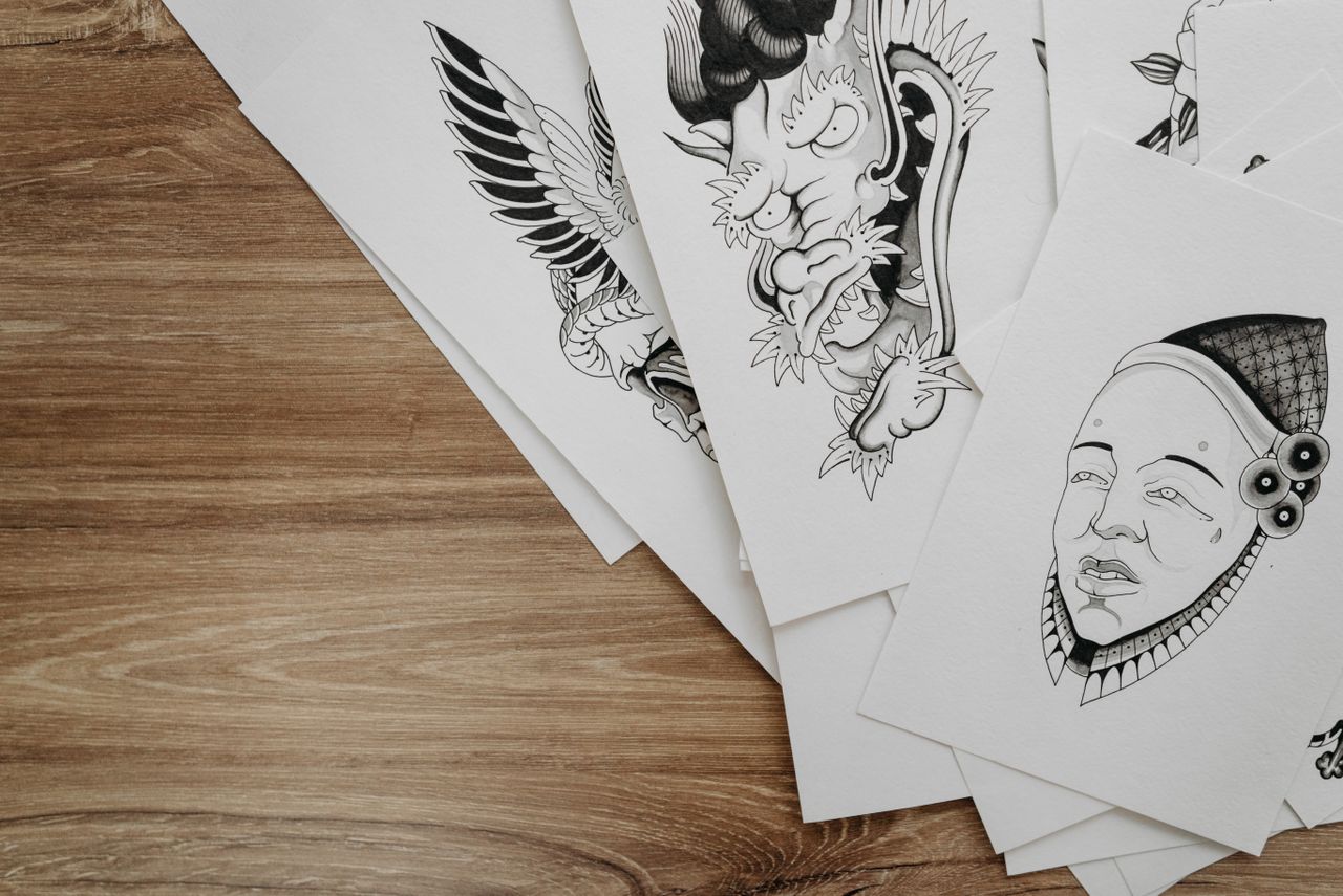 top view of detailed black and white drawings on paper arranged on a w