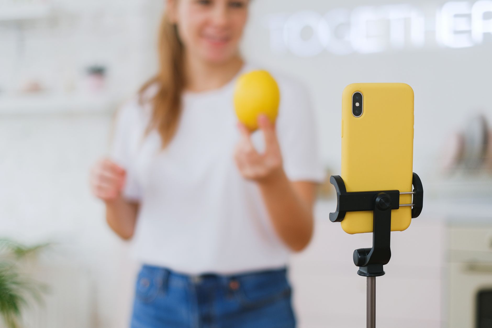 Mulher gravando um vlog de culinária com limão em uma cozinha, ilustrando estudos de caso marketing de influencia