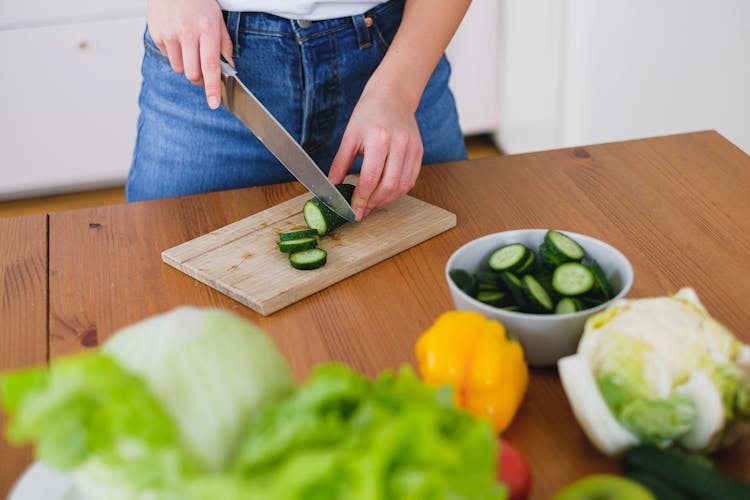 Person Slicing A Green Cucumber