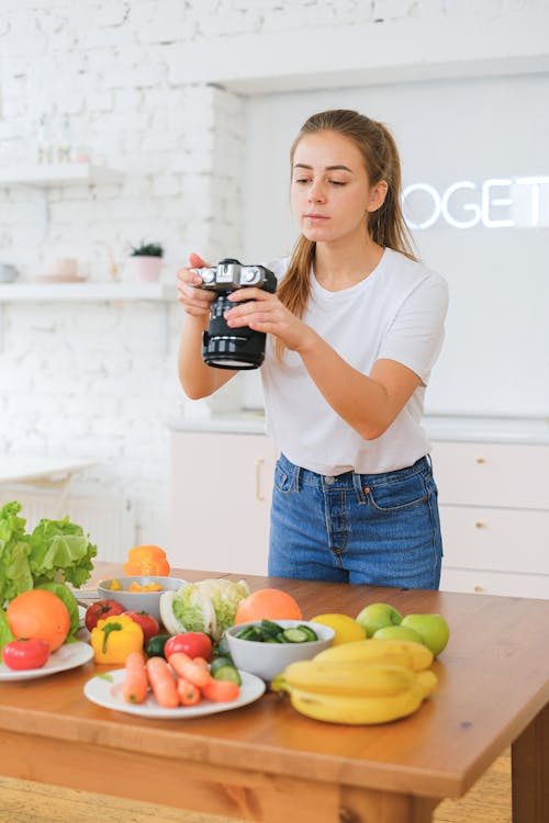 Free Woman Taking Photo of Food on Table Stock Photo