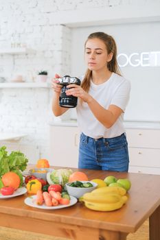 Woman photographing fresh fruits and vegetables on a wooden table indoors.