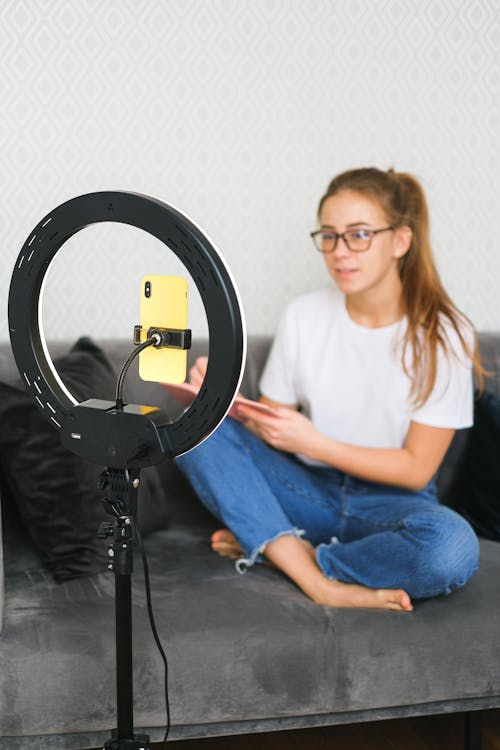 Woman Sitting Near a Ring Light