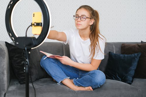 Woman Holding a Book While Blogging