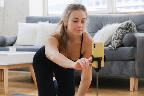 Woman Kneeling While Using a Cellphone