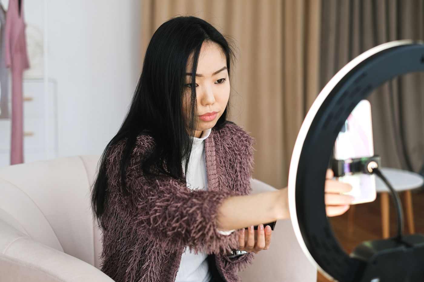 UGC creator filming herself with a smartphone and ring light in a home setup