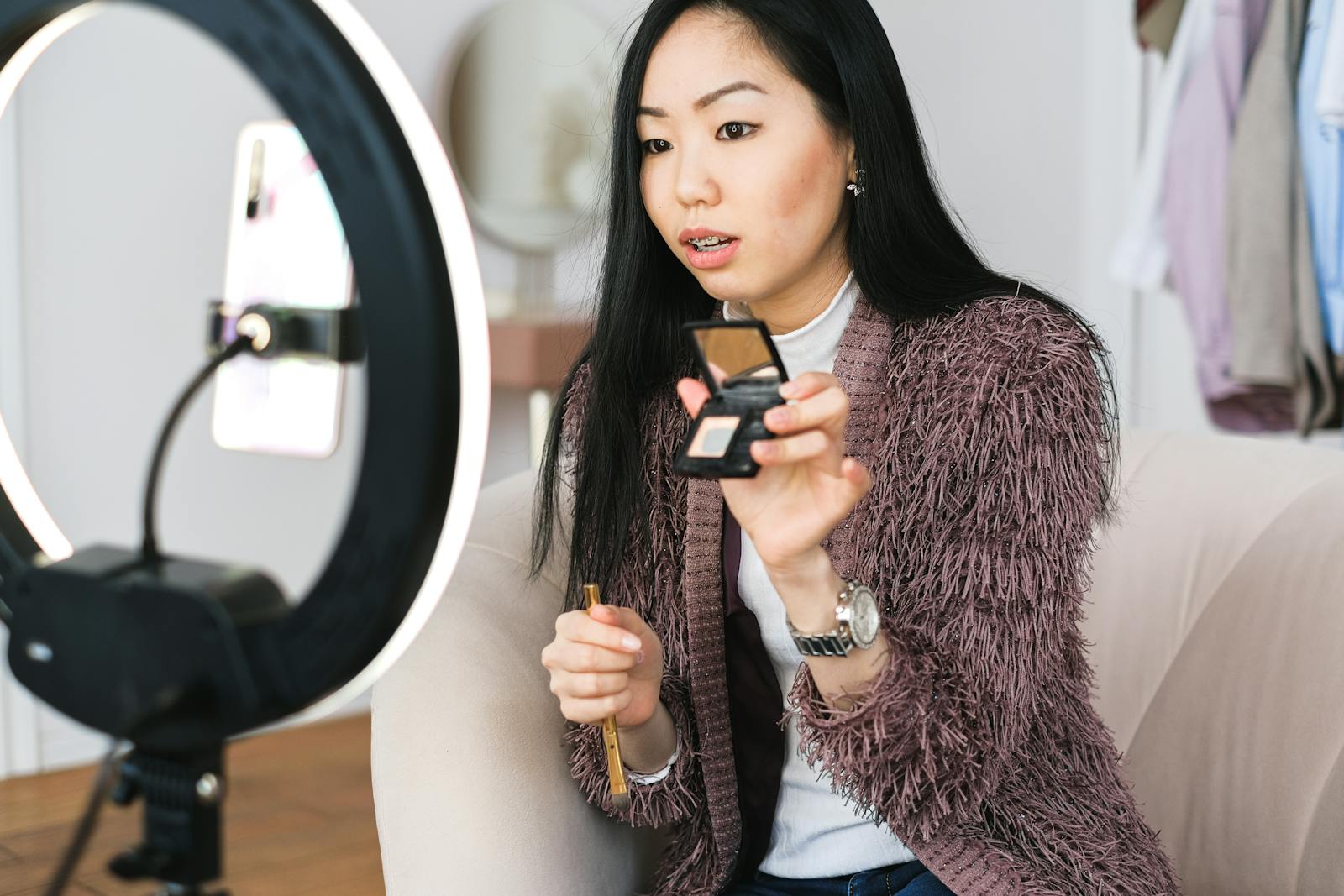 Woman applying makeup with ring light in front-facing position