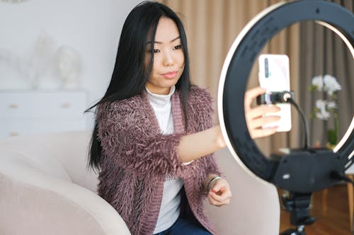 Woman in Cardigan Holding a Cellphone