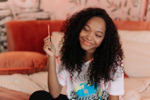 Smiling Woman Holding a Lip Gloss Brush 