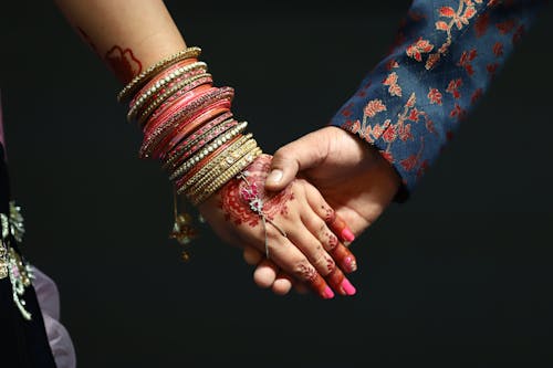 Close up of Hands Holding with Henna Tattoo and Bracelets