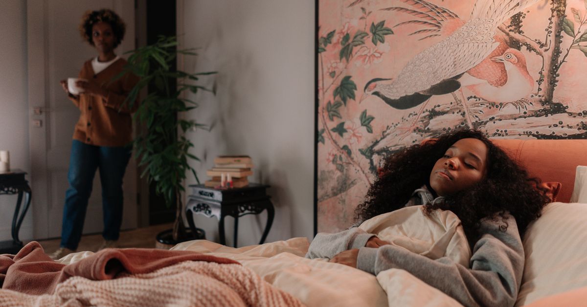 A mother brings tea to her sleeping daughter in a warmly decorated bedroom with artwork. - Evidence evidence guide for green tea sleep randomized trial