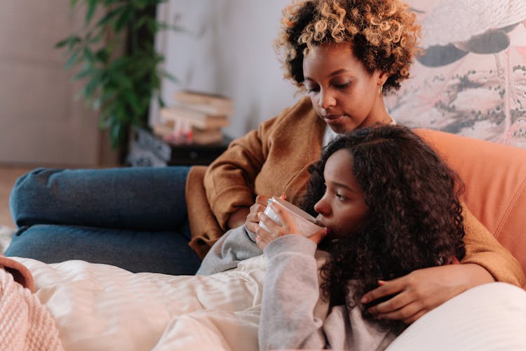 Mother And Daughter Sitting On The Couch