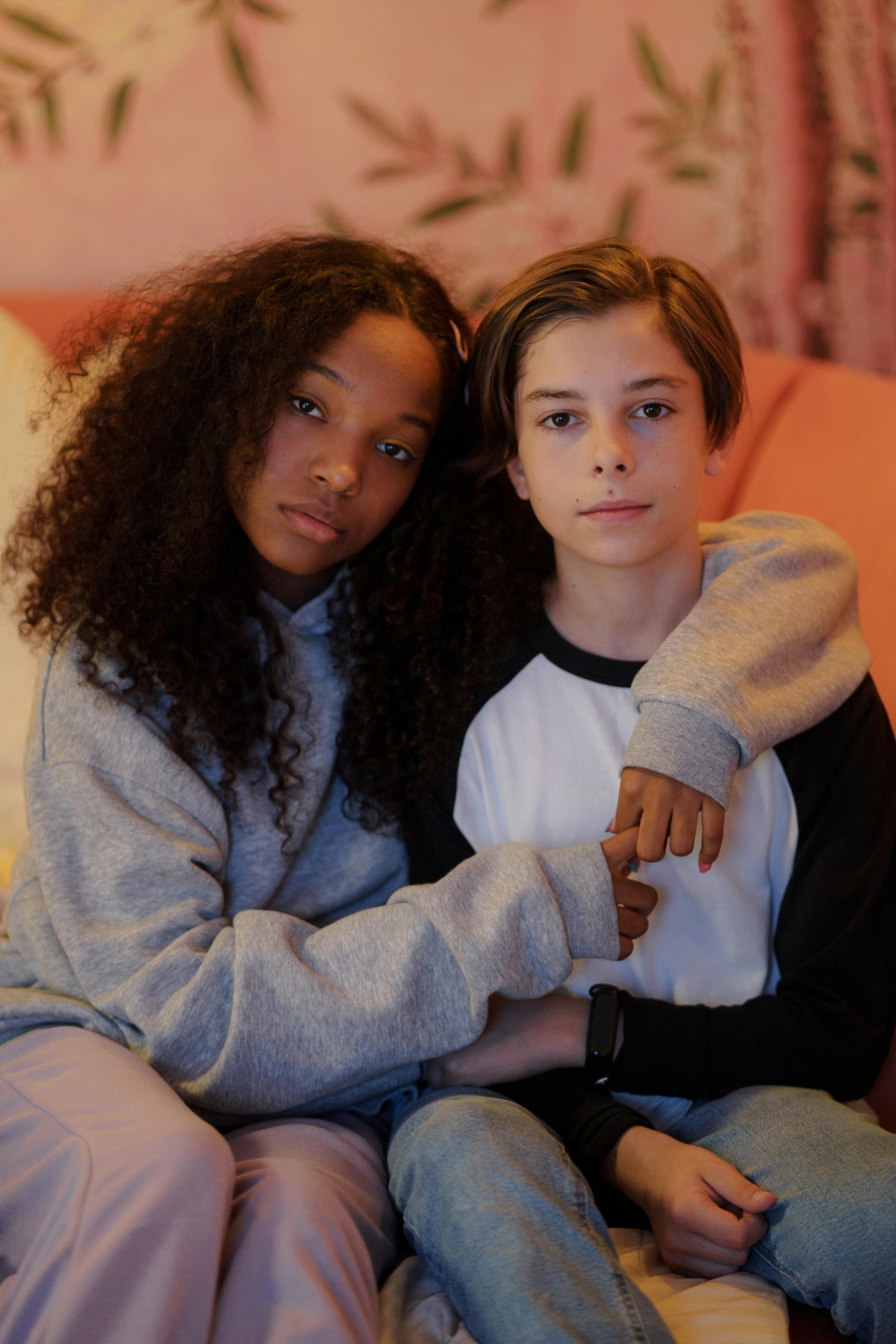 A Young Girl in Gray Sweater Embracing a Boy · Free Stock Photo