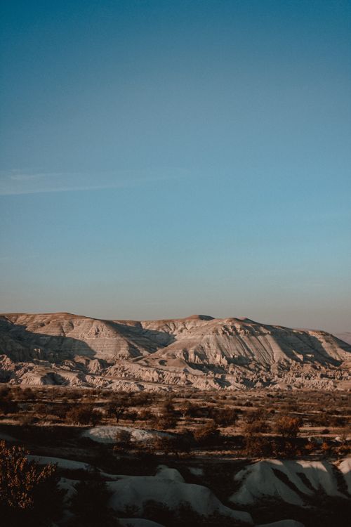 Free Breathtaking view of rocky eroded formations in a desert landscape under a clear sky at dawn. Stock Photo
