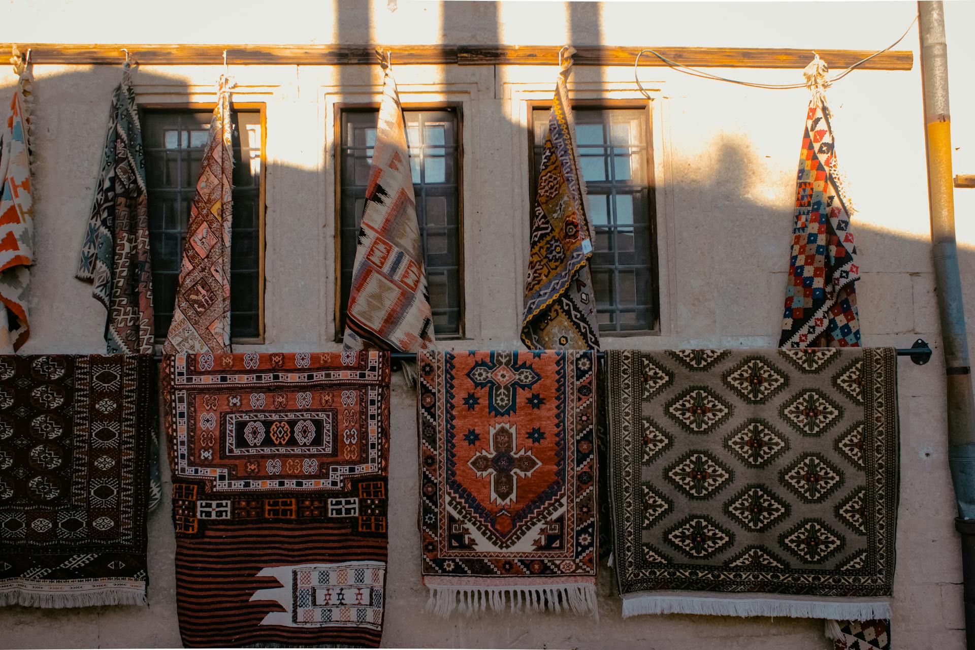 Patterned Rugs Hanging on a Building Wall 