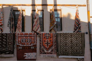 Patterned Rugs Hanging on a Building Wall 