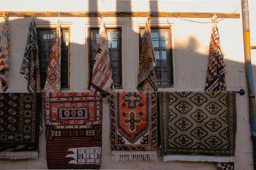 Free Assorted handmade carpets hanging on a wall in Nevşehir, Türkiye. Stock Photo