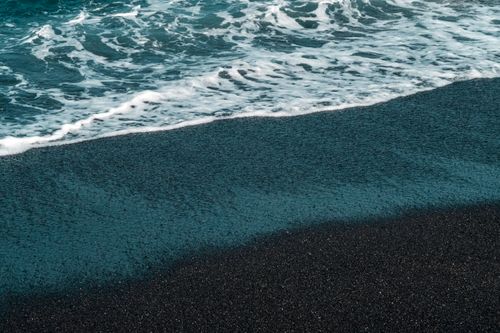 Free Black sand beach with foamy ocean waves, offering a serene outdoor scene. Stock Photo
