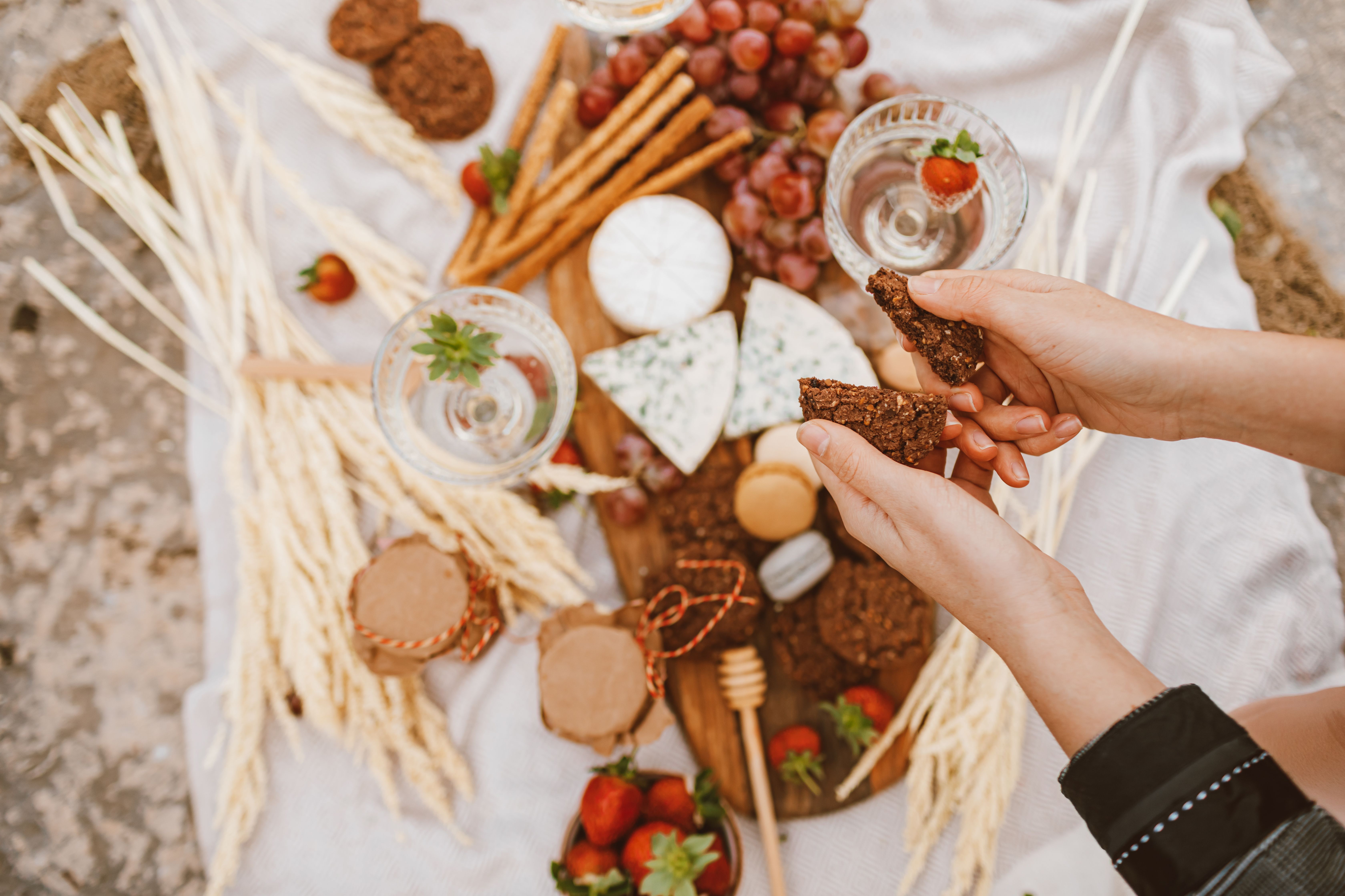 A well-arranged chocolate and cheese board with fruits, nuts, and honey