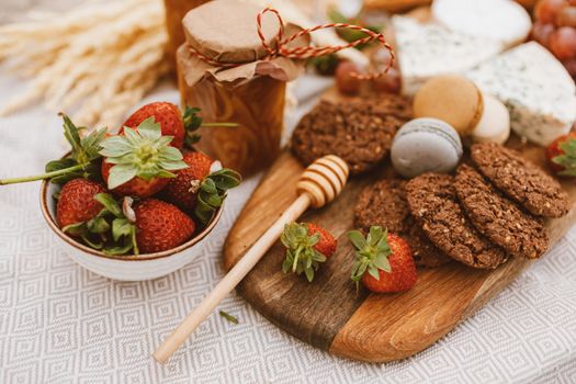 Delicious breakfast spread with fresh strawberries, cookies, and assorted cheeses.