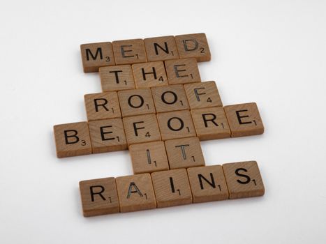 Scrabble tiles on a white background with the phrase 'Mend the roof before it rains'.