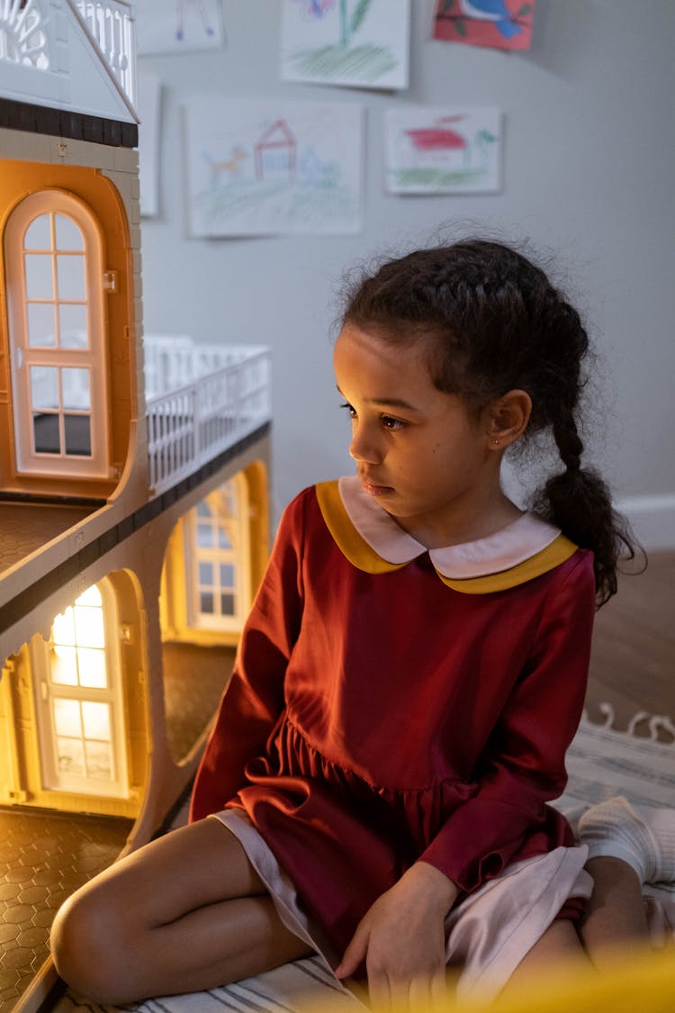 Girl Playing With A Dollhouse