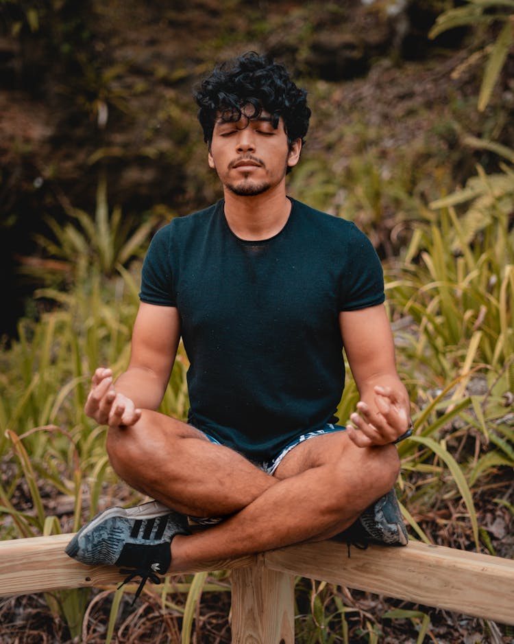 A Young Man In Activewear Meditating