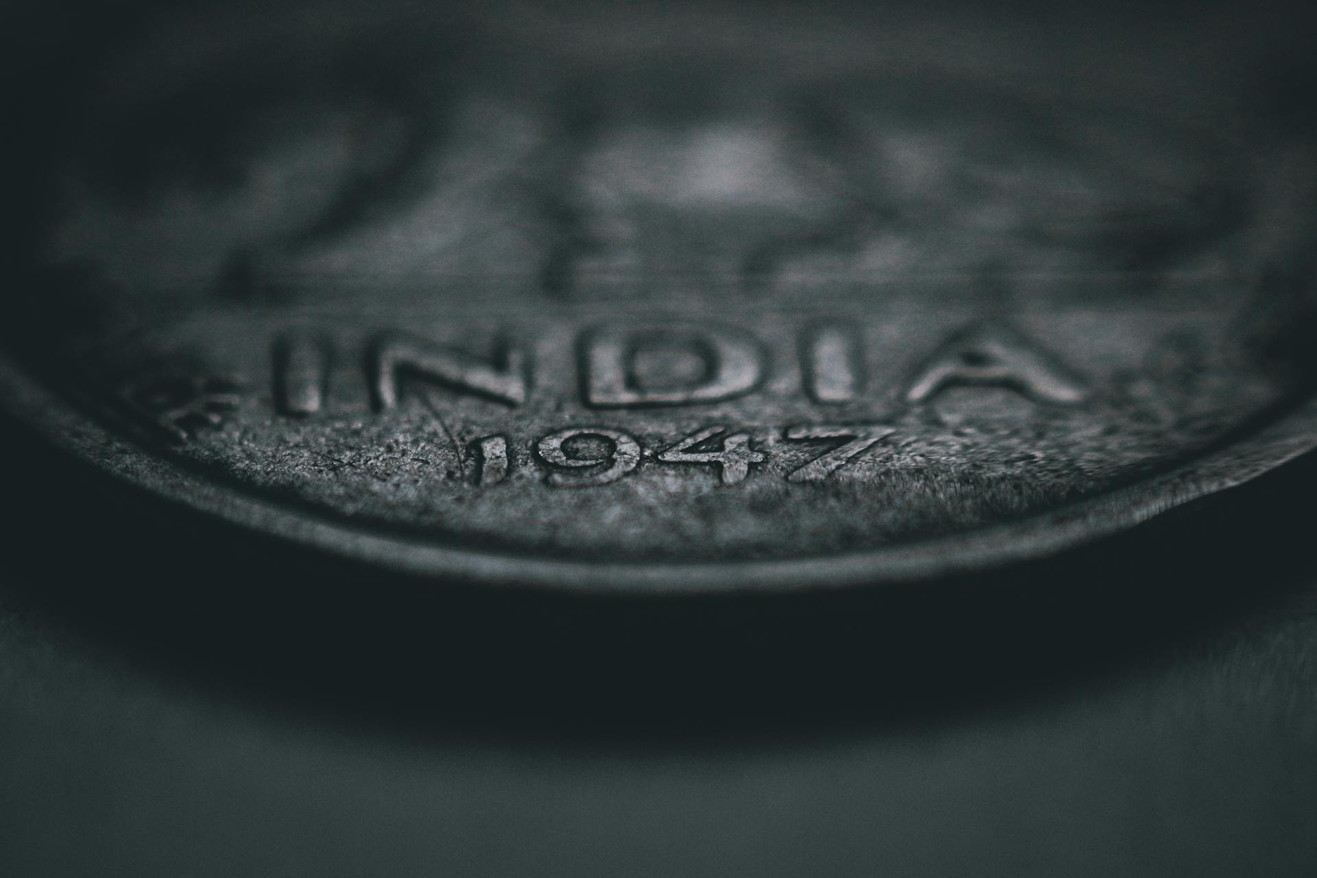 Close-up of a vintage Indian coin dated 1947, showcasing intricate details and texture.