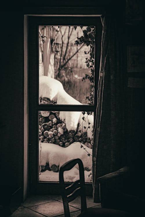 Chair in Dark Room and Winter Behind Window