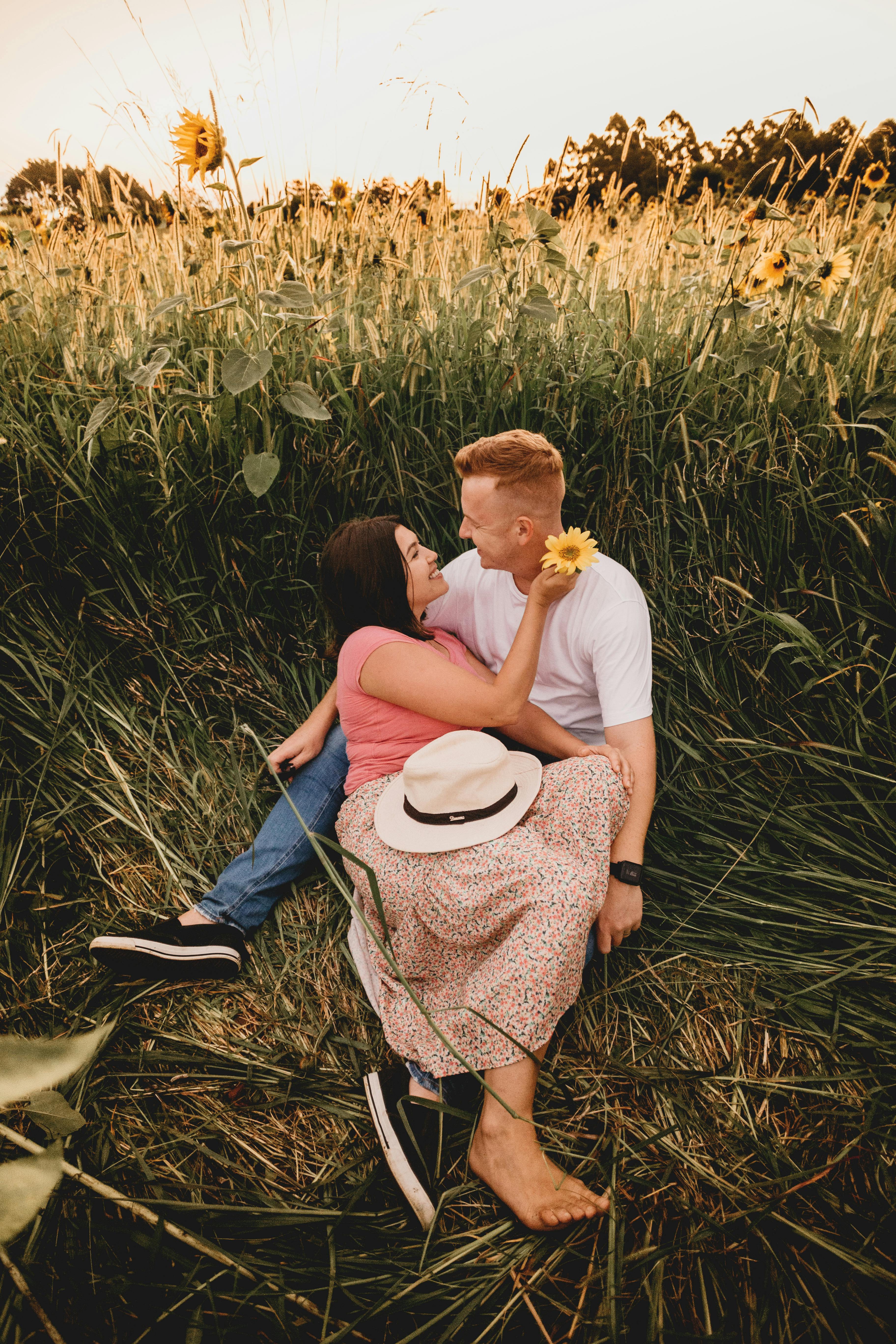 cheerful couple lying on lush grass in countryside