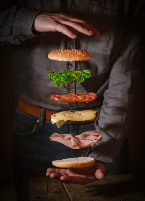 Free Person in Black Shirt Holding Burger Stock Photo